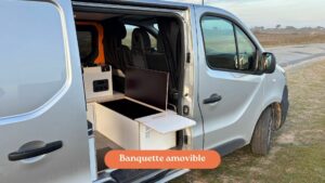 Fiat Talento II 2021 aménagé avec une banquette amovible et espace de rangement optimisé pour les voyages en van.
