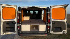 Fiat Talento II 2021 aménagé en mode couchage avec lit convertible et rangements intégrés, idéal pour les voyages en van.