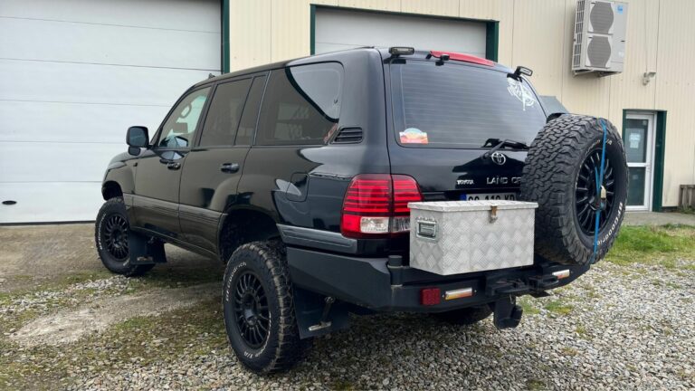 Toyota Land Cruiser SW tout-terrain, équipé d’un pare-chocs arrière renforcé, roue de secours et coffre en aluminium.