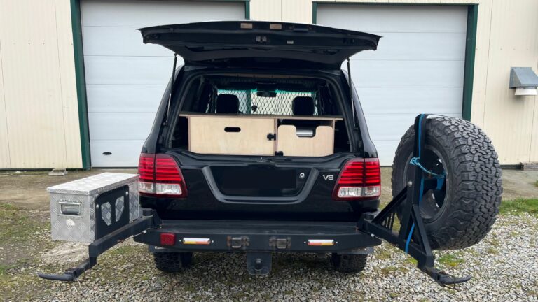 Aménagement camping dans un Toyota Land Cruiser SW avec tiroirs de rangement et modules en bois pour l’aventure et le tout-terrain.