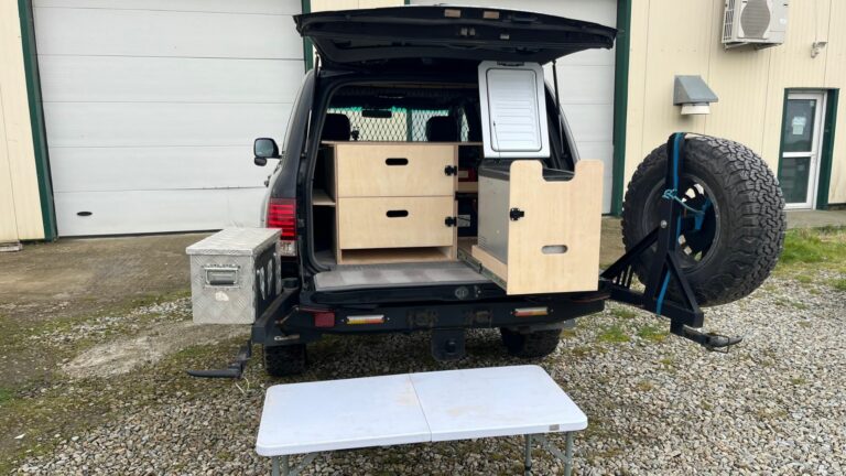 Aménagement camping dans un Toyota Land Cruiser SW avec tiroirs de rangement et modules en bois pour l’aventure et le tout-terrain.