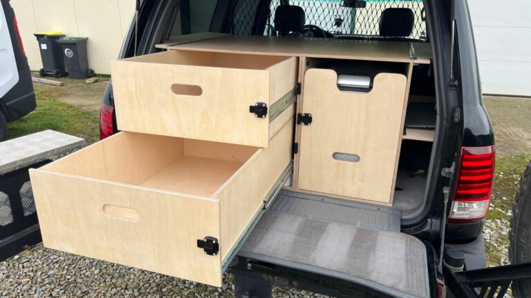 Aménagement camping dans un Toyota Land Cruiser SW avec tiroirs de rangement et modules en bois pour l’aventure et le tout-terrain.