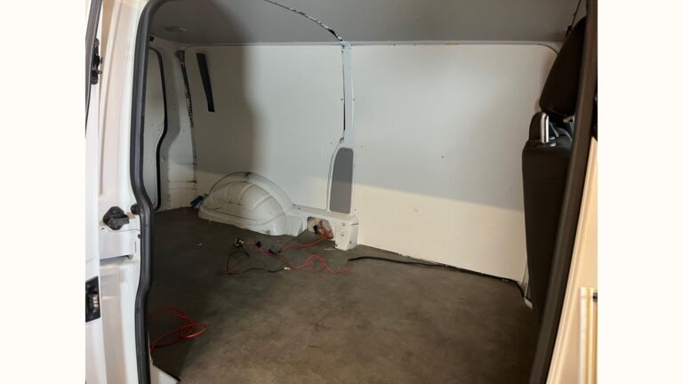 Vue latérale intérieure d’un Volkswagen T6 vide avant aménagement, prêt à recevoir des meubles et rangements sur mesure.