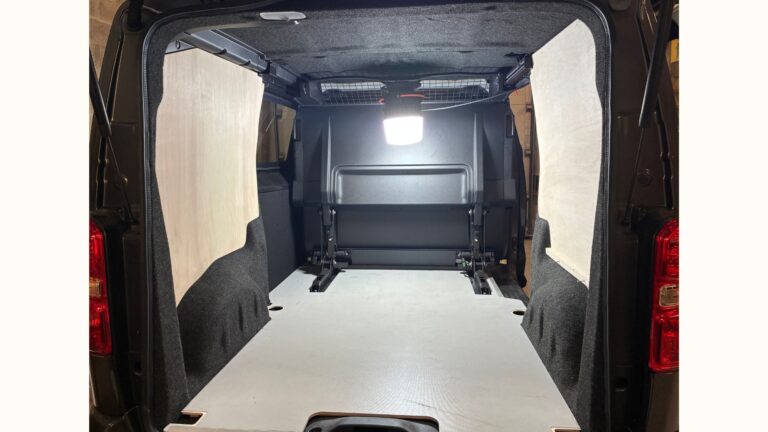 Habillage bois et moquette sur les parois d’un Peugeot Expert cabine approfondie, étape clé d’un aménagement sur mesure pour VTT.
